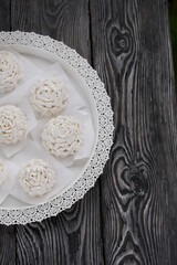 Marshmallow cones. Homemade zephyr. Arranged on a platter. On the background of the boards. Taken from above.