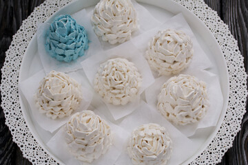 Marshmallow cones. Homemade zephyr. Arranged on a platter. On the background of the boards. Taken from above.