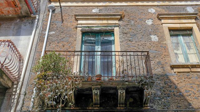 Aci Bonaccorsi, Sicily. Early in the morning, typical balcony of an antique house made with lavic stones.