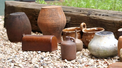 Clay pots arranged in a row as a decoration, an ornament in the garden. - obrazy, fototapety, plakaty