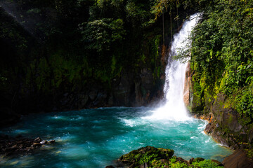 panorama of the famous rio celeste waterfall in volcano tenorio national park in costa rica; a blue waterfall in a tropical rainforest