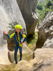 Adrenaline sport - Canyoning. Child with neoprene in mountain ravine