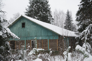 an old abandoned building in winter in the woods