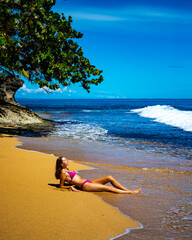 beautiful girl in a bikini lies on the sand on a Caribbean beach in Costa Rica; sunbathing on a...