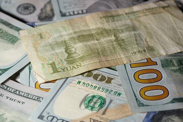 One Chinese yuan bank note on USA dollars background