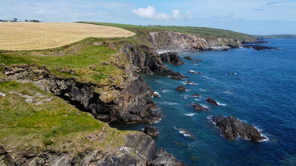 Fototapeta na wymiar Farm fields on the shore of the Celtic Sea, south of Ireland, County Cork. Beautiful coastal area. Turquoise waters of the Atlantic. Picturesque stone hills.