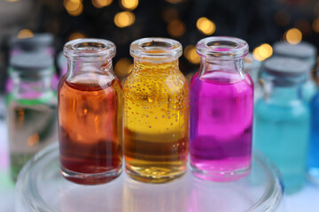 Fototapeta na wymiar Aqueous solutions of red, yellow and purple indicator dyes are in three glass jars.
