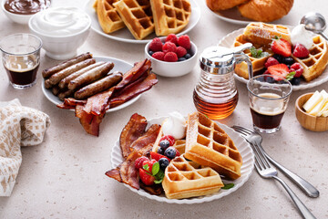 Breakfast table with waffles, croissants and bacon