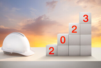 engineer working table and golden sky for preparation of welcome 2023 new year party .change and growing up for new construction business.