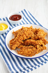 Homemade Chicken Strips with Mustard and BBQ on a Plate, side view.