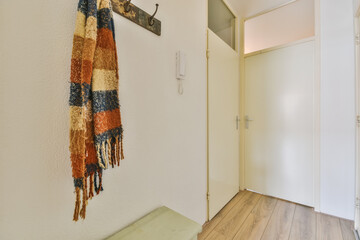 an empty room with a scarf hanging on the wall and a door to another room in the photo is taken