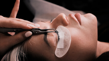 Cosmetologist installing eye pads before eyelash extensions