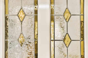 two glass doors with gold and white designs on the front, one door is open to reveal an image of...