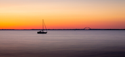 Segelschiff in der Ferne bei Sonnenaufgang 