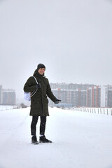 Traveling in winter through a snow-covered city, a young man in winter against the background of a snow-covered city.
