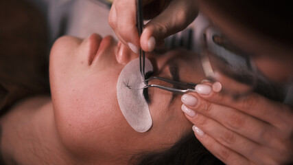 Beautician removes eyelashes that were glued badly