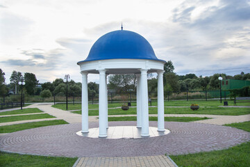 gazebo with blue roof and white pillars at sunset