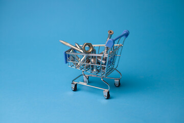 fasteners nuts screws bolts screws in a shopping cart on a bright blue background. for labels,...