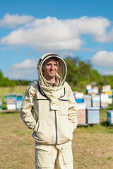 Professional beekeeper in protective suit. Apiary worker in the honeycomb field.