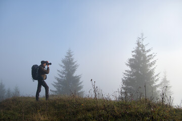 Fototapeta na wymiar Photographer hiker taking picture of nature with digital camera