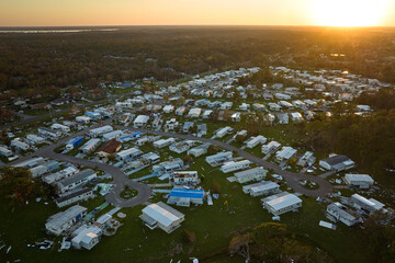 Severely damaged by hurricane Ian houses in Florida mobile home residential area. Consequences of...