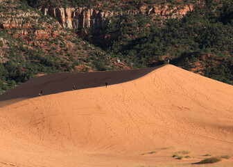 Hikers along the ridge of the colorful Coral Pink Sand Dunes near Kanab, Utah