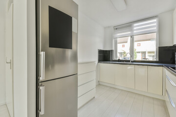 a modern kitchen with white cabinets and black counter tops on the island in this photo is taken...
