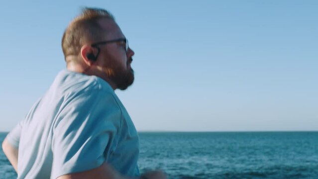 Plus size man, running or fitness by beach, ocean or sea in weightloss control, fat management or body goals wellness. Chubby runner, sports or athlete in nature exercise, training or health workout