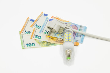 Electric plug, light bulb, and the euro money banknotes. Concept of increasing energy costs