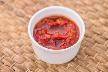 Hot chili sauce served in dish isolated on table side view of arabic food