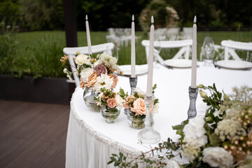Main table at a wedding reception with beautiful fresh flowers. Outside wedding decorations.