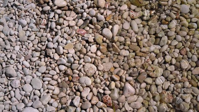 Sun shines to small gravel stones at Limni beach in Corfu, Greece - sea is crystal clear here