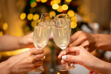 Hands of young people clinking with glass of champagne to celebrate and toasting with happiness in holiday
