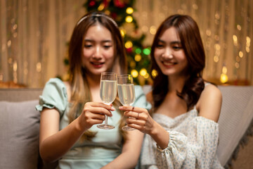 Young beautiful people sitting on the couch and clinking glass of champagne to toasting with happiness