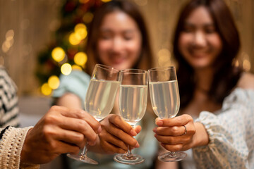 Young people is sitting on the couch and clinking with glass of champagne for celebration while toasting
