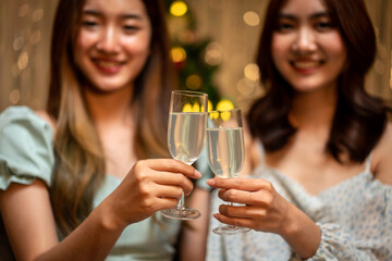 Young beautiful people is sitting on the couch to clinking glass of champagne to toasting with happiness