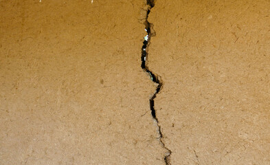 split and cracked adobe wall, wall slit, damaged adobe wall, village wall,