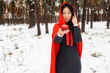 Red Hooded Woman Holding an Apple Fairytale Portrait - Fairytale image of a beautiful girl in a red...