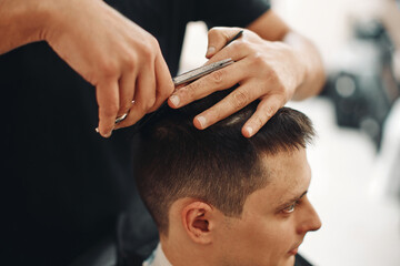 hairdresser does haircut for man in barber shop