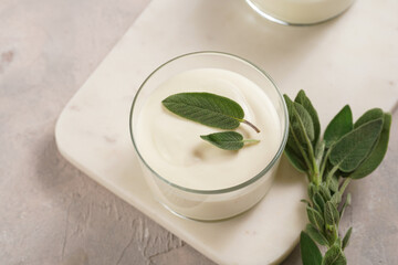 Creamy dairy yoghurt dessert sweet mousse with mascarpone, cream cheese, sage and lemon juice in glasses on marble tray