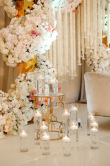 Restaurant interior covered with floral arrangements and lighting candles, prepared for celebrating an event