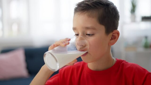 Closeup of schoolboy enjoying drinking milk, getting calcium for healthy bones