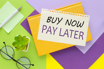 Buy Now Pay Later .text in yellow notepad. bright green and purple background
