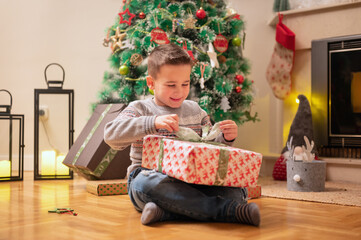 Obraz na płótnie Canvas Boy opening christmas present. High quality photography.