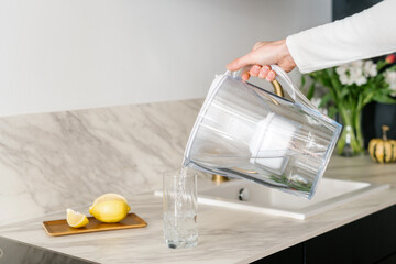 woman drink water from filter jug indoors, closeup