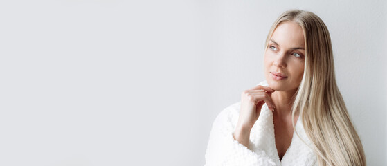 Thoughtful woman in bathrobe choosing beauty procedure