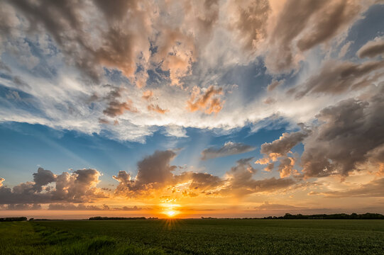 Sunset and big sky with cloud over fields of farmland; Saskatchewan, Canada