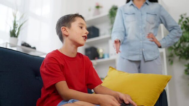 Mother taking away joystick from son, preventing child's game addiction 