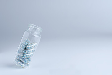 glass medical bottle with blue pills inside