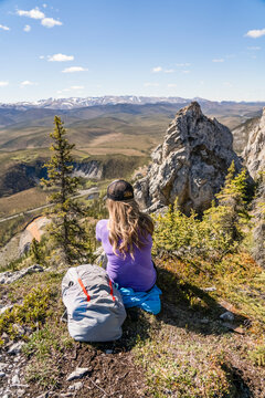 Woman hiking along the Dempster Highway enjoying the scenery on top of Sapper Hill; Yukon, Canada
